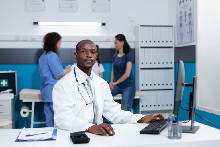 portrait d un medecin pediatre afro americain assis a une table de bureau au bureau de l hopital 1 2 768x512